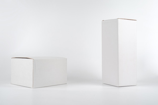 Photo white two paper boxes tall and fat lay on the white background in studio shot with clipping paht