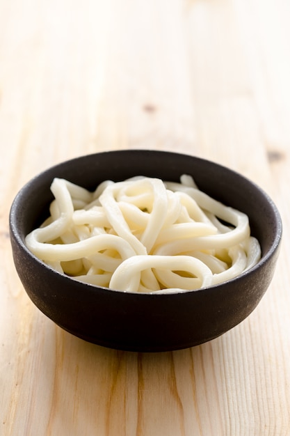 White udon noodle in black bowl 