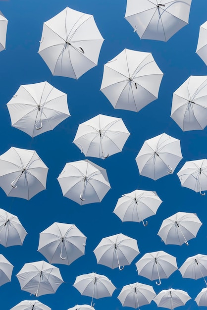 White umbrellas on blue sky
