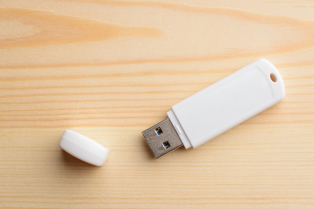 White USB stick with cap on a light wooden table