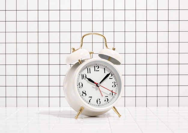 White vintage alarm clock on table Deadline office work