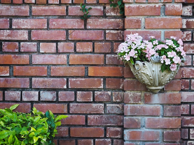 White vintage flowerpot hanging on old brick wall