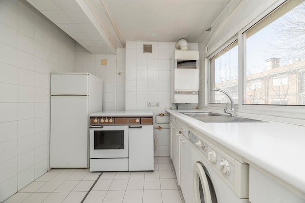 White vintage kitchen with window with views white appliances and stoneware floors of the same color