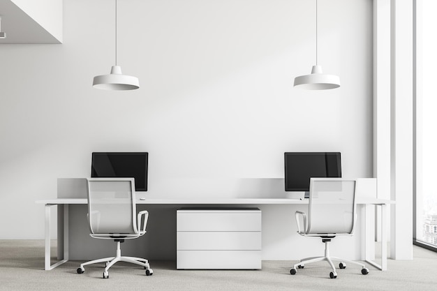 White wall office interior with loft windows, a concrete floor and rows of computer tables. 3d rendering mock up