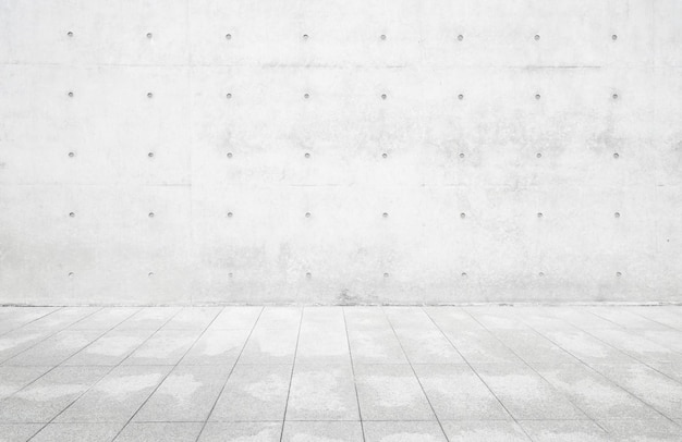 A white wall with a concrete floor and a concrete floor