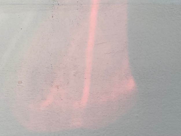 A white wall with a pink light on it