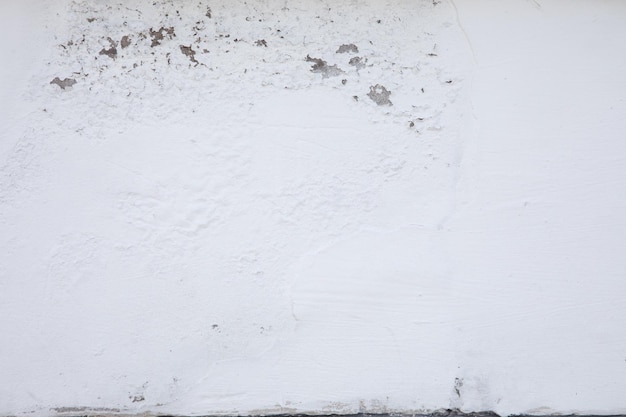 A white wall with a worn out paint job.