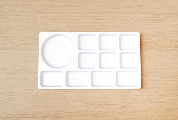 White watercolor palette Empty watercolor tray isolated on wood background White paint palette