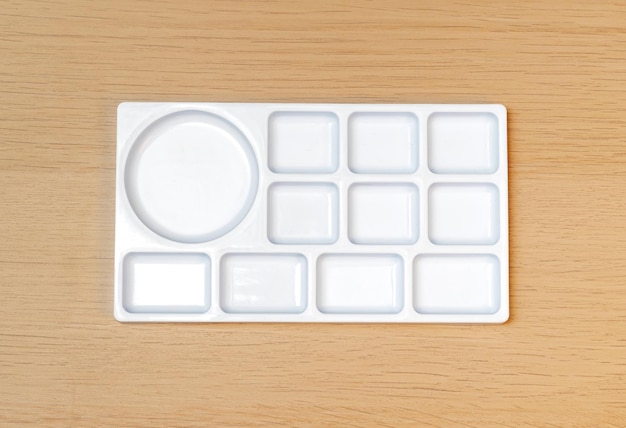 White watercolor palette Empty watercolor tray isolated on wood background White palette