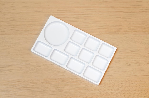 White watercolor palette Empty watercolor tray isolated on wood background