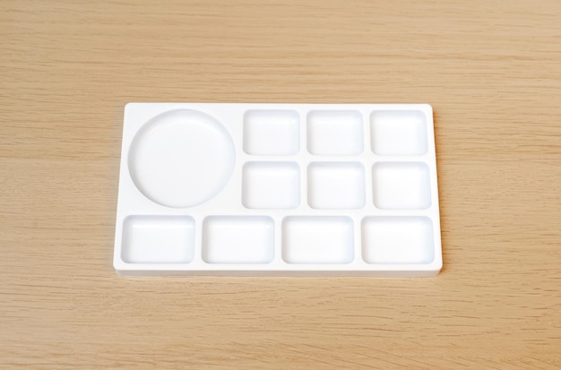 White watercolor palette Empty watercolor tray isolated on wood background