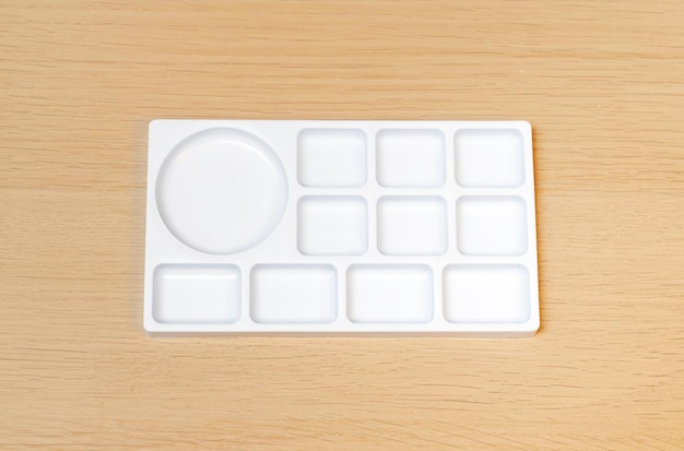 White watercolor palette Empty watercolor tray isolated on wood background