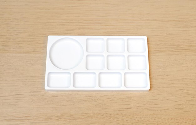 White watercolor palette Empty watercolor tray isolated on wood background