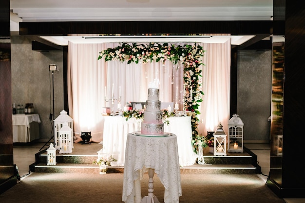 Белый свадебный торт с розовыми цветами и зеленью на праздничном столе с выпечкой крупным планом торт Сладкий стол