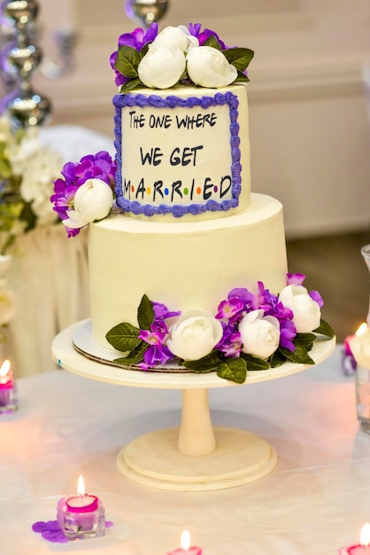 White wedding cake with text the one where we get married