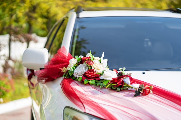 White wedding car decorated with fresh flowers. Wedding decorations.