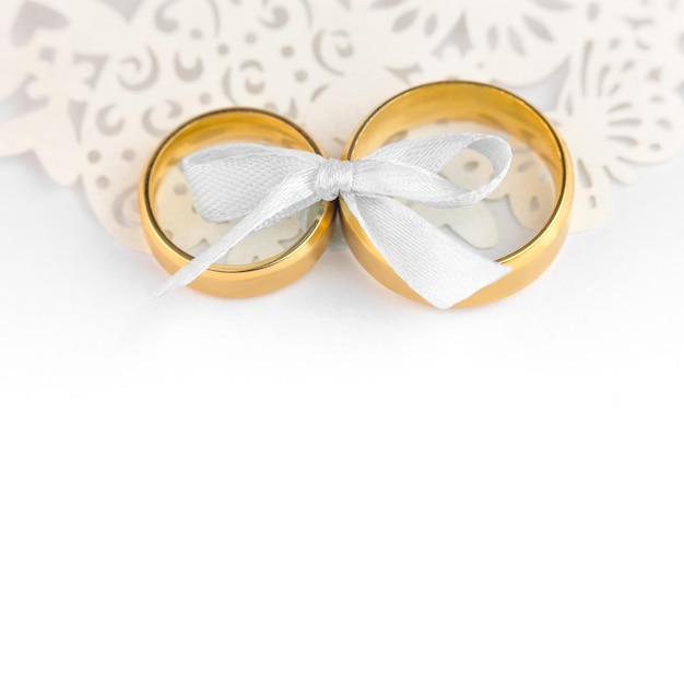 White Wedding Celebration background pair of wedding rings with bow and copy space for text