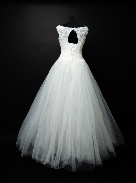 White wedding dress on black background in studio