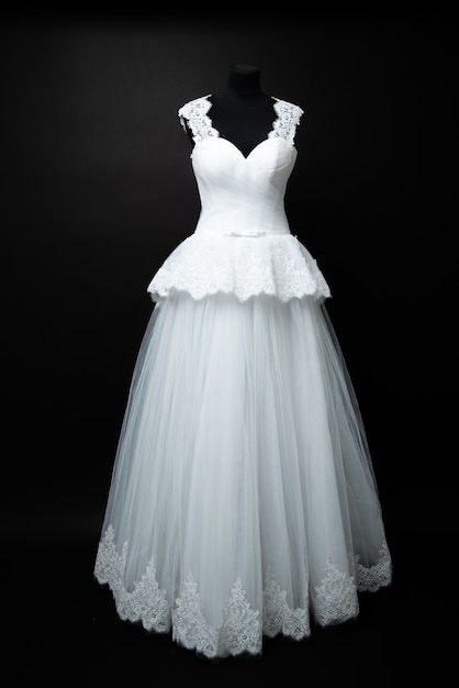 White wedding dress on black background in studio