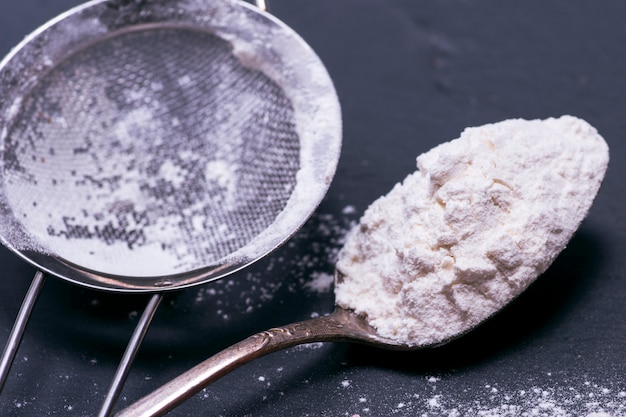 White wheat flour in an iron spoon 