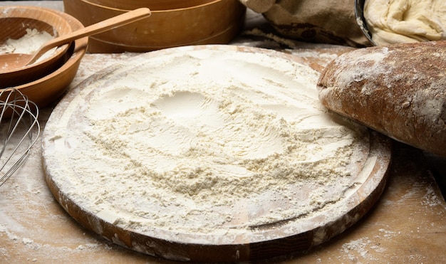 Foto farina di grano bianco e rotolo di legno a bordo ingredienti per la cottura da vicino