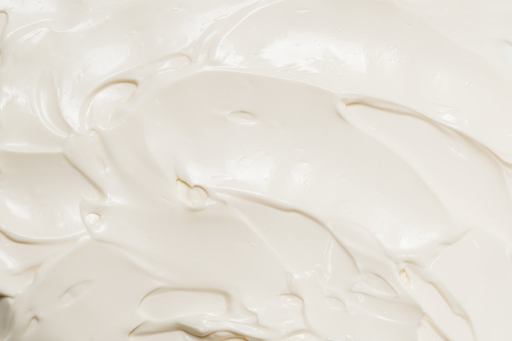 Photo white whipped cream texture. top view.