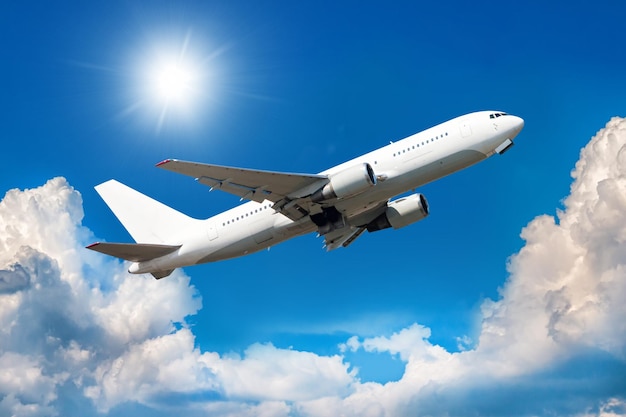 Белый широкофюзеляжный пассажирский самолет поднимается в воздух над живописными облаками