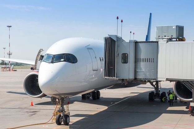 White wide body passenger airplane at the boarding bridge