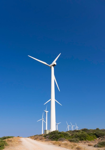 White wind turbines against the blue sky on the Greek island of Evia in Greece