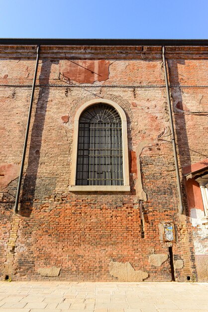 Photo white window on old house wall cracks in concrete visible red bricks