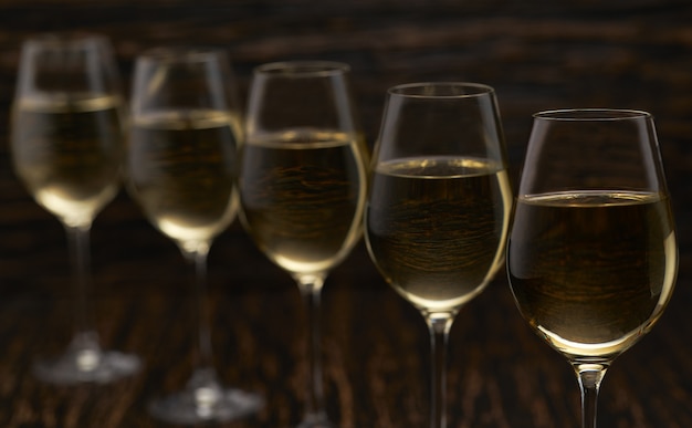 White wine on a black wooden table, close up.