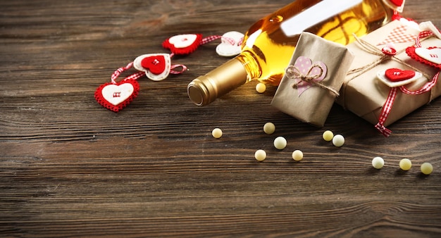 White wine bottle and gift box on wooden background