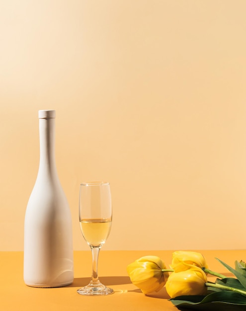 White wine bottle and glass Elegant celebration composition Tulip flowers on table Party concept