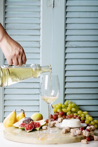 Vino bianco in un bicchiere servito con frutta fresca