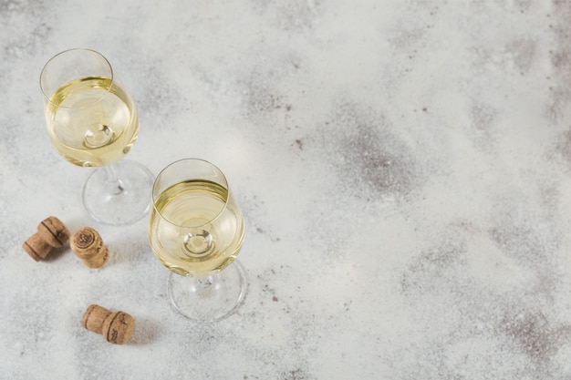 밝은 회색 표면에 화이트 와인. 비노 베르데 와인 잔 2 개. 계절 휴일 개념.