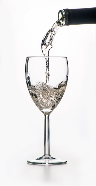 white wine pouring into a glass from a bottle