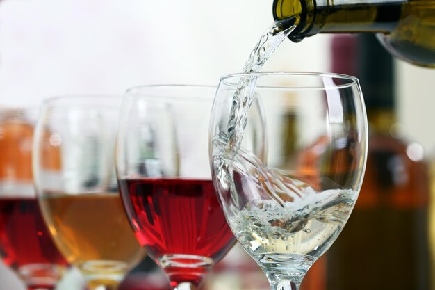 White wine pouring into glasses closeup