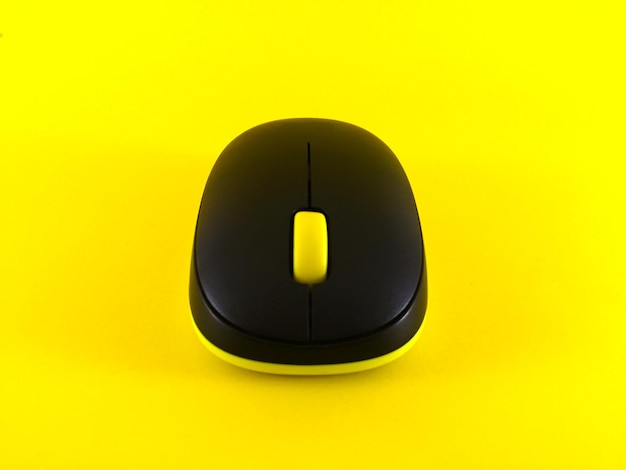 White wireless mouse on yellow background minimal flatlay