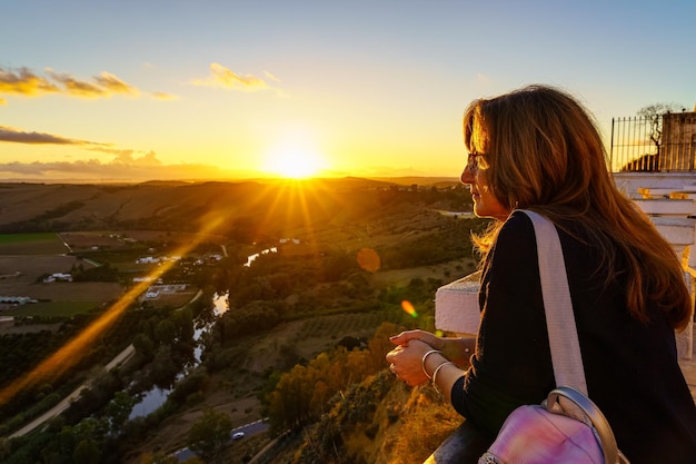 White woman enjoying the views of a sunset over the countryside of a village in Cadiz Andalucia