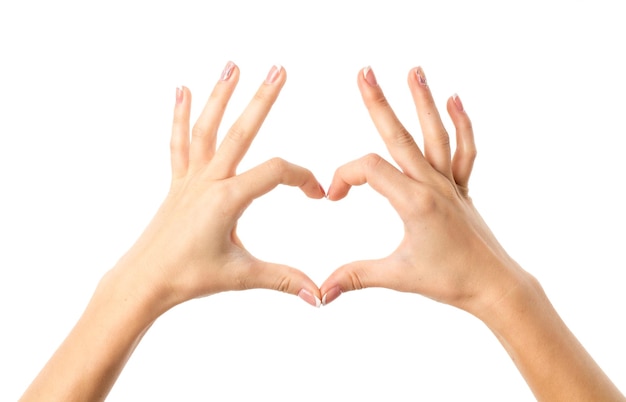 White woman's hands making heart on white background in studio