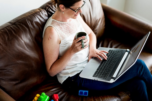 White woman using laptop at sofa