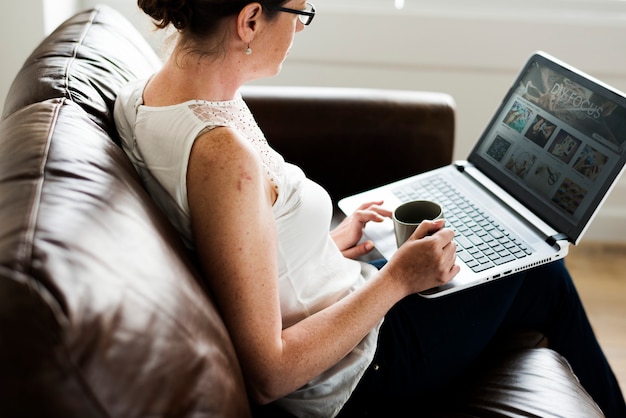 Photo white woman using laptop at sofa