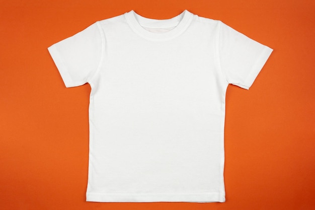 オレンジ色の背景に白いレディース コットン t シャツ モックアップ デザイン t シャツ テンプレート印刷プレゼンテーション モックアップ トップ ビュー フラット レイアウト