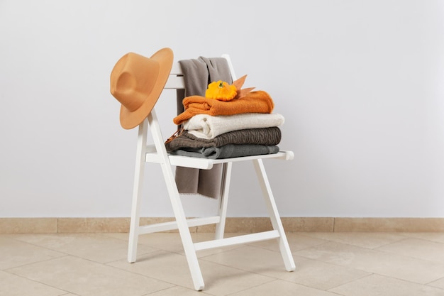 White wooden chair with autumn clothes and accessories