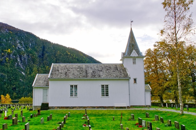 Photo white wooden church with slate roof in a norwegian valley