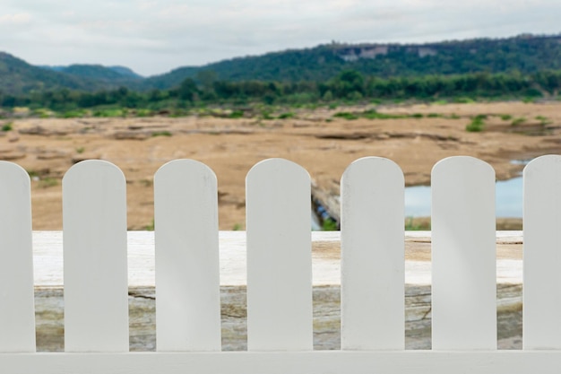 White wooden fence isolated on a blurry mountain and sky background that separates the objects