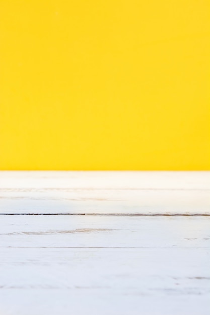 Фото Белый деревянный пол и желтый фон копией пространства