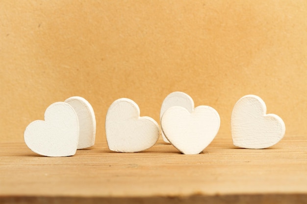 White wooden hearts on a wooden table in a front view