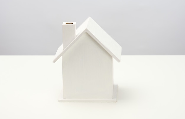 Premium Photo | White wooden house on a gray background. real estate