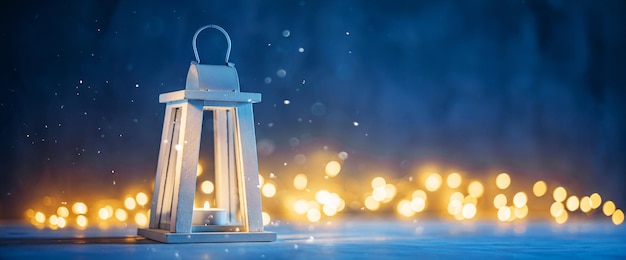 Foto lanterna di legno bianca con una candela sotto la nevicata sullo sfondo delle luci bokeh accogliente atmosfera natalizia
